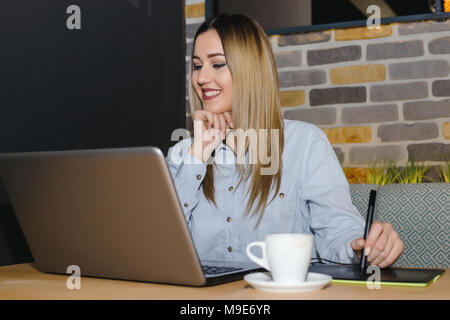 Grafik Designer bei Tisch sitzen im Cafe und Verwendung digitaler Tablet und Computer Tools arbeiten an einem neuen Projekt. Stockfoto