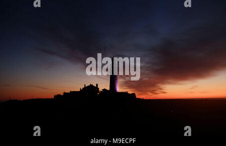 Die Sonne geht hinter der St Mary's Leuchtturm, Whitley Bay in Tyne und Wear. Stockfoto