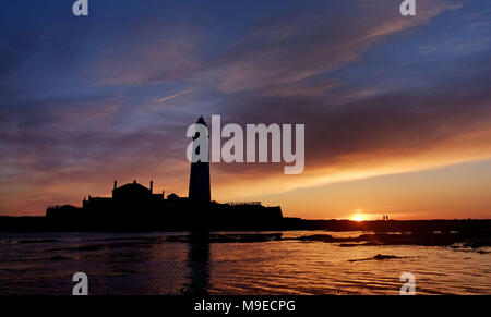 Die Sonne geht hinter der St Mary's Leuchtturm, Whitley Bay in Tyne und Wear. Stockfoto