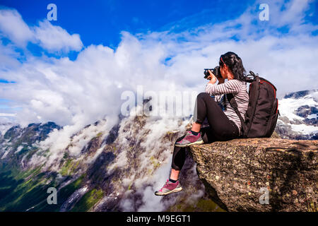 Natur-Fotograf-Tourist mit Kamera schießt beim stehen oben auf dem Berg. Wunderschöne Natur Norwegens. Stockfoto