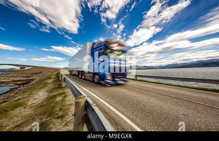 Lkw Rast auf der Autobahn im Hintergrund Atlantik Straße Norwegen. Lkw Auto in Bewegungsunschärfe. Stockfoto