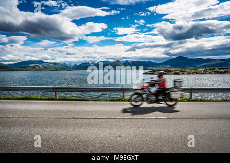 Biker fährt eine Straße mit Atlantik Straße in Norwegen. Atlantik Straße oder den Atlantik Straße (atlanterhavsveien) den Titel als 'Norwegian Con ausgezeichnet. Stockfoto