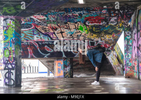 Ein Mädchen Geschichten ein selfie von sich selbst in der Graffiti schwere Umgebung der Skatepark in der Londoner South Bank Stockfoto