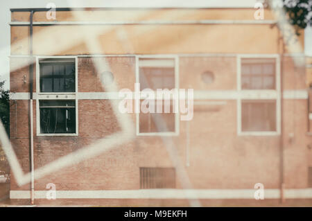 Fassade der Alten und Verlassenen zerstörten Schule in doppelte Exposition Zusammensetzung, bereit für Renovierung Stockfoto