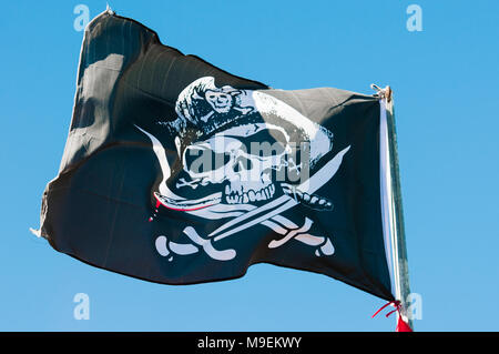 Schwarze und weiße Totenkopf Piratenflagge auf einem Fahnenmast. Stockfoto