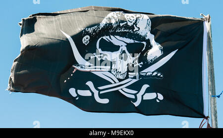 Schwarze und weiße Totenkopf Piratenflagge auf einem Fahnenmast. Stockfoto