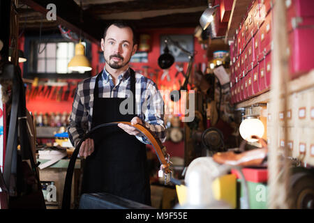 Junge ernsthaften Arbeiter demonstrieren Sortiment in Leder workshop Stockfoto