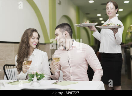 Frau Kellner bedienen die Gäste Tisch im Restaurant. Fokus auf den Menschen Stockfoto