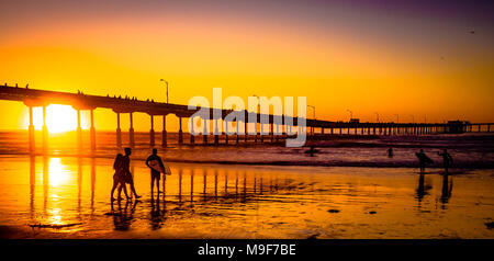 Sonnenuntergang am Ocean Beach Pier in San Diego, mit Menschen, zu Surfen. Stockfoto