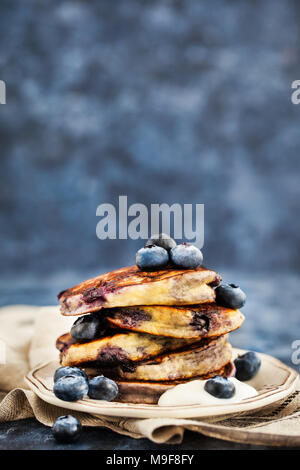 Stapel von frisch zubereiteten Blueberry ricotta Pfannkuchen mit frischen Beeren, Joghurt und Honig zum Frühstück Stockfoto