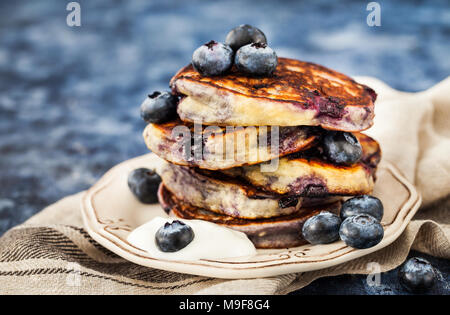 Stapel von frisch zubereiteten Blueberry ricotta Pfannkuchen mit frischen Beeren, Joghurt und Honig zum Frühstück Stockfoto