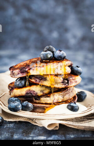 Stapel von frisch zubereiteten Blueberry ricotta Pfannkuchen mit frischen Beeren, Joghurt und Honig zum Frühstück Stockfoto