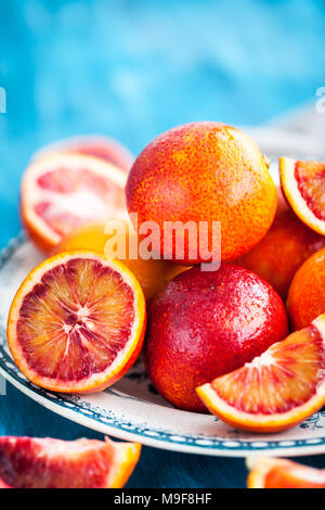 In Scheiben geschnitten und ganze frische reife saftige sizilianischer Blutorangen Stockfoto