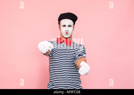 Closeup Portrait von Treiber Mann fahren mit dem Auto. Clown, Artist, Mime. Studio shot, rosa Hintergrund Stockfoto