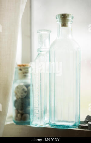 Hellblau-grün Glasflaschen auf dem Fensterbrett in der Sonne Stockfoto