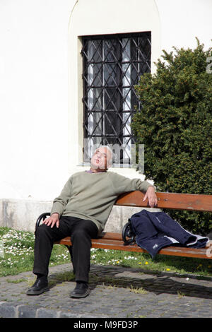 Mann der schläft auf einer Parkbank in der ungarischen Hauptstadt Budapest Ungarn Stockfoto