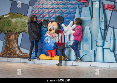 Kinder mit einer Micky Maus Statue innerhalb des Terminals am Internationalen Flughafen Orlando Florida USA posieren. Stockfoto