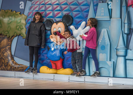 Kinder mit einer Micky Maus Statue innerhalb des Terminals am Internationalen Flughafen Orlando Florida USA posieren. Stockfoto