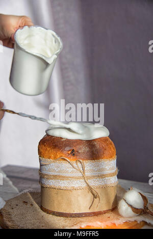 Ostern Kuchen in den Händen des Mädchens Sahne zum Kuchen hinzufügen Stockfoto