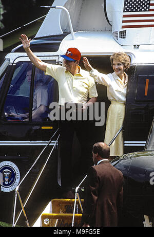 Washington, DC., USA, Oktober 1984 US-Präsident Ronald Reagan und First Lady Nancy Reagan Wave aus der Schritte von Marine One wie Sie sind zu einem kurzen Flug vom Süden Rasen des Weißen Hauses nehmen nach Camp David die Präsidentenrückzug Lage in Maryland Berge. Credit: Mark Reinstein/MediaPunch Stockfoto