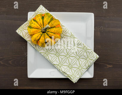 Acorn Squash befindet sich an der Ecke des Serviette und Platte auf hölzernen Tisch Stockfoto