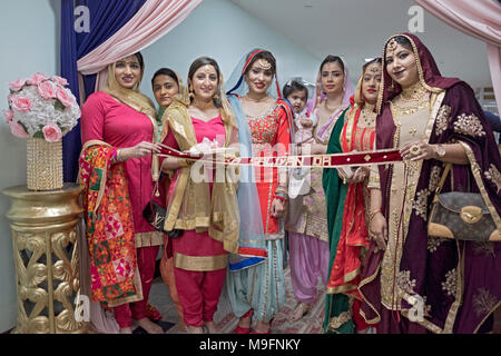 Schöne Sikh Frauen an der Naka Sallyan Da Ribbon Cutting bei einer Hochzeit in Rochmond Hills, Queens New York. Stockfoto