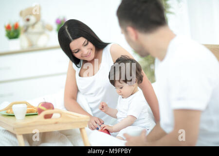 Familie mit Baby, Frühstück im Bett. Stockfoto