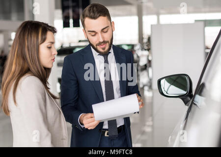 Stattliche Autoverkäufer im Gespräch mit Kunden Stockfoto