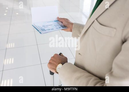 Mann hält Tickets im Flughafen Stockfoto