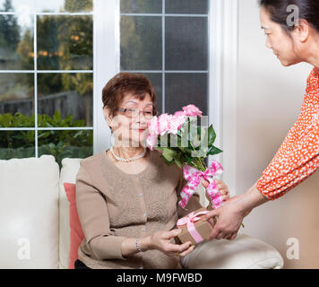 Ältere Frau Geschenke, die von ihrer Tochter für Muttertag Stockfoto