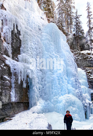 42,749.08947 Frau in einer tiefen Winter schneebedeckten zugefrorenen Fluss Canyon (Maligne River Canyon) suchen Bei frozen Eiswände Eisfälle Stockfoto