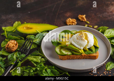 Frische avocado Frühstück mit Ei Benedikt Sandwich. Grüner Salat und Samen, gesunde, vegetarische Essen Konzept. Essen Hintergrund, kopieren. Stockfoto