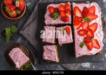 Joghurt pound Kuchen zum Frühstück mit rosa Glasur und frische Erdbeeren. Dunkler Hintergrund, Sommer Nachtisch. Ansicht von oben, kopieren. Stockfoto