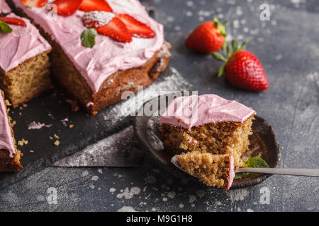 Joghurt pound Kuchen zum Frühstück mit rosa Glasur und frische Erdbeeren. Dunkler Hintergrund, Sommer Nachtisch. Stockfoto