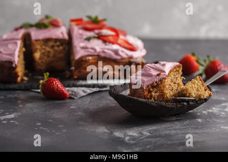 Joghurt pound Kuchen zum Frühstück mit rosa Glasur und frische Erdbeeren. Dunkler Hintergrund, Sommer Nachtisch. Stockfoto