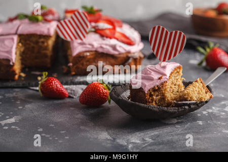 Valentinstag Kuchen zum Frühstück mit rosa Glasur und frische Erdbeeren. Dunkler Hintergrund, Sommer Nachtisch. Stockfoto