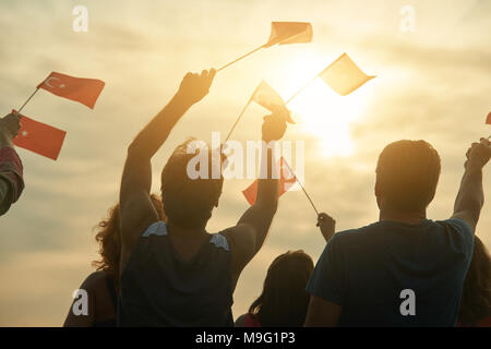 Ansicht von Hinten Nahaufnahme reife Männer mit türkischen Flaggen. Hellen Abendhimmel an der nach unten. Stockfoto