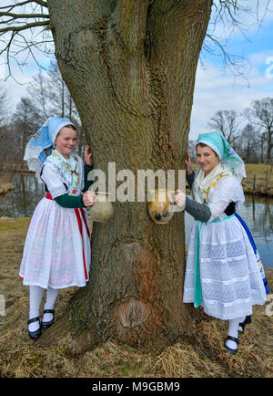 24 März 2018, Deutschland, Schlepzig: Zwei Schwestern Aliena (L) und Leonie Huber zeigt in Sorbischen und Wendischen festliche Tracht in einem geschlechtsgeruches Szene der Lausitz brauch Osterwasser holen am Fluss Spreewald Dorf Schlepzig. Frauen und Mädchen gehen mit Tonkrüge zu einem Fluß und Wasser in der Nacht holen vor dem Ostersonntag. Auf dem Weg dorthin und zurück keine Worte gesprochen werden. Das Wasser hat eine besondere magische Kraft die Auszeichnung Schönheit und Gesundheit. Foto: Patrick Pleul/dpa-Zentralbild/ZB Stockfoto