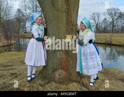 Abbildung - 24 März 2018, Deutschland, Schlepzig: Zwei Schwestern Aliena (L) und Leonie Huber zeigt in Sorbischen und Wendischen festliche Tracht in einem geschlechtsgeruches Szene der Lausitz brauch Osterwasser holen am Fluss Spreewald Dorf Schlepzig. Frauen und Mädchen gehen mit Tonkrüge zu einem Fluß und Wasser in der Nacht holen vor dem Ostersonntag. Auf dem Weg dorthin und zurück keine Worte gesprochen werden. Das Wasser hat eine besondere magische Kraft die Auszeichnung Schönheit und Gesundheit. Foto: Patrick Pleul/dpa-Zentralbild/ZB Stockfoto