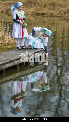 Abbildung - 24 März 2018, Deutschland, Schlepzig: Zwei Schwestern Aliena (L) und Leonie Huber zeigt in Sorbischen und Wendischen festliche Tracht in einem geschlechtsgeruches Szene der Lausitz brauch Osterwasser holen am Fluss Spreewald Dorf Schlepzig. Frauen und Mädchen gehen mit Tonkrüge zu einem Fluß und Wasser in der Nacht holen vor dem Ostersonntag. Auf dem Weg dorthin und zurück keine Worte gesprochen werden. Das Wasser hat eine besondere magische Kraft die Auszeichnung Schönheit und Gesundheit. Foto: Patrick Pleul/dpa-Zentralbild/ZB Stockfoto