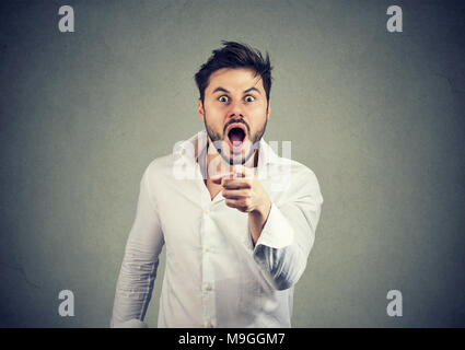 Junge schockiert Mann im weißen Hemd, der auf der Kamera angibt und die Schuld zu geben. Stockfoto