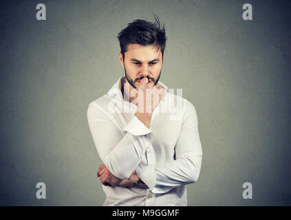 Junge ernsten Menschen berühren Lippen und Suchen während der Lösung grosse Frage im Verstand besorgt. Stockfoto