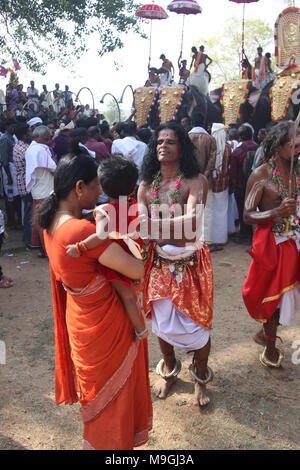 Velichapad, der Vertreter von Göttin bhagavathi segnet ein Kind während der Tempel Festival Stockfoto