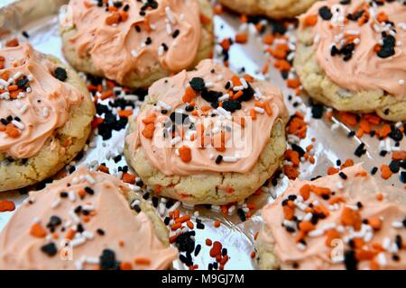 Sugar Cookies mit orangefarbenem Zuckerguss und Streuseln Stockfoto