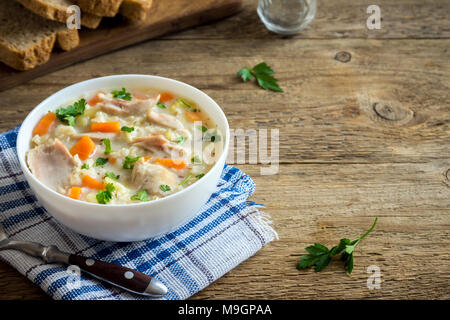 Huhn und wilder Reis Suppe. Hausgemachte frische cremige Suppe mit Hähnchen, Gemüse und Wildreis in weiße Schüssel. Stockfoto