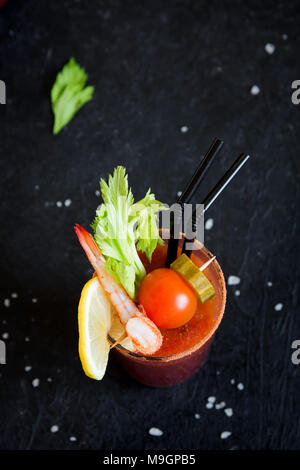 Bloody Mary Cocktail in Glas mit Beilagen. Tomate Bloody Mary würzige Drink auf schwarzen Hintergrund mit kopieren. Stockfoto