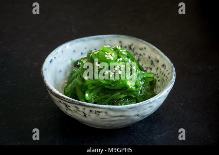 Chuka Algensalat in Keramik Schüssel über schwarzen Hintergrund, kopieren. Japanische Küche - Chuka Salat Stockfoto