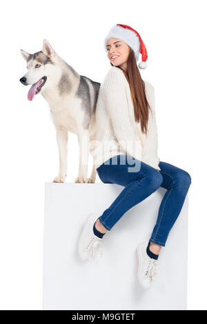 Husky Hund und schöne Mädchen in santa hut, isoliert auf weißem Stockfoto