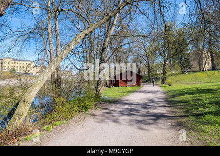 Nicht erkennbare Personen entlang der Fluss Motala im Frühjahr in Norrköping. Norrköping ist eine historische Stadt in Schweden. Stockfoto