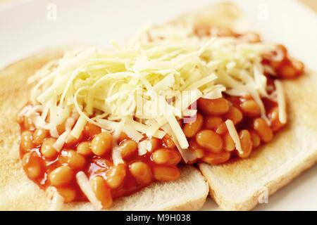 Gebackene Bohnen auf Toast überbacken mit Geriebener Cheddar-Käse Stockfoto